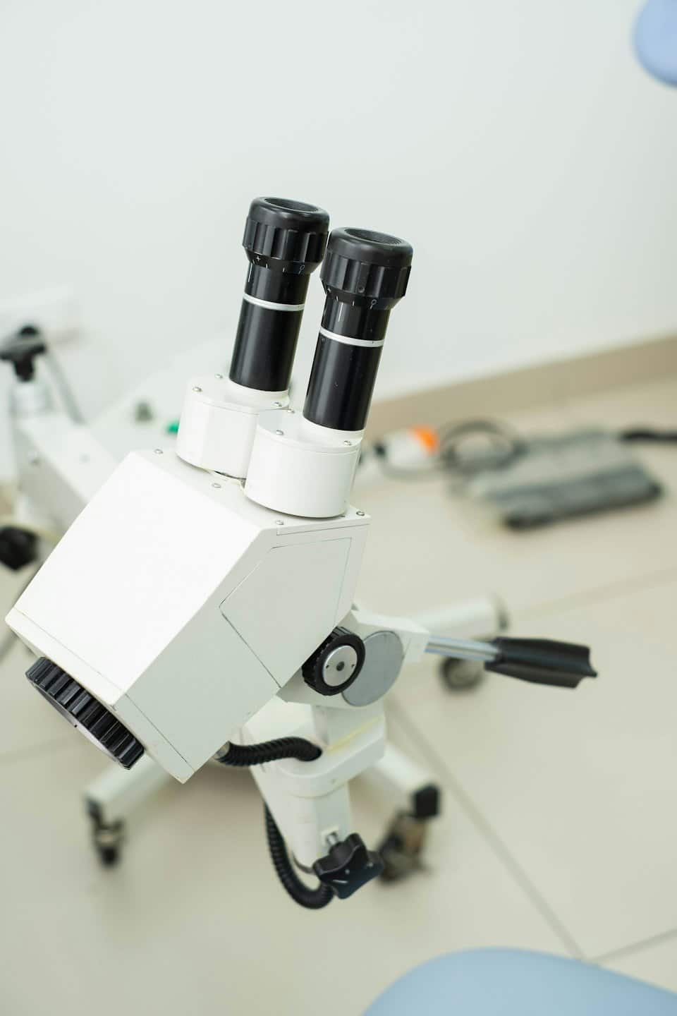 Microscopio medico bianco su un tavolo da visita clinica.